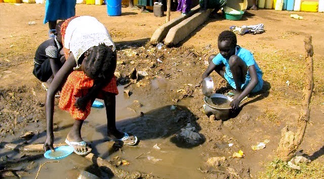 Flyktninger henter vann fra en vannhull utenfor Dzaipi i Uganda, på grensen til Sør-Sudan. Det er lite vann i flyktningleiren. Foto: CARE